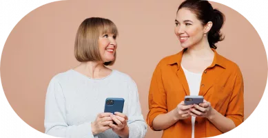 Zwei fröhliche Frauen mit Handys in der Hand